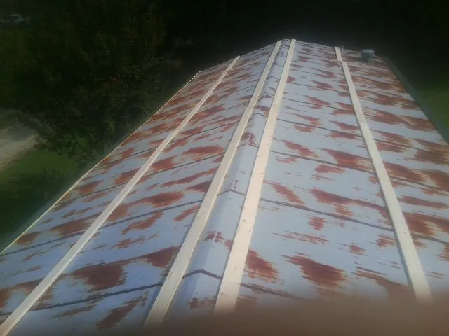 Rusted metal roof panels with new wood purlins before replacement — Storm Damage Roof Repair in North Highlands by Roofing Brothers