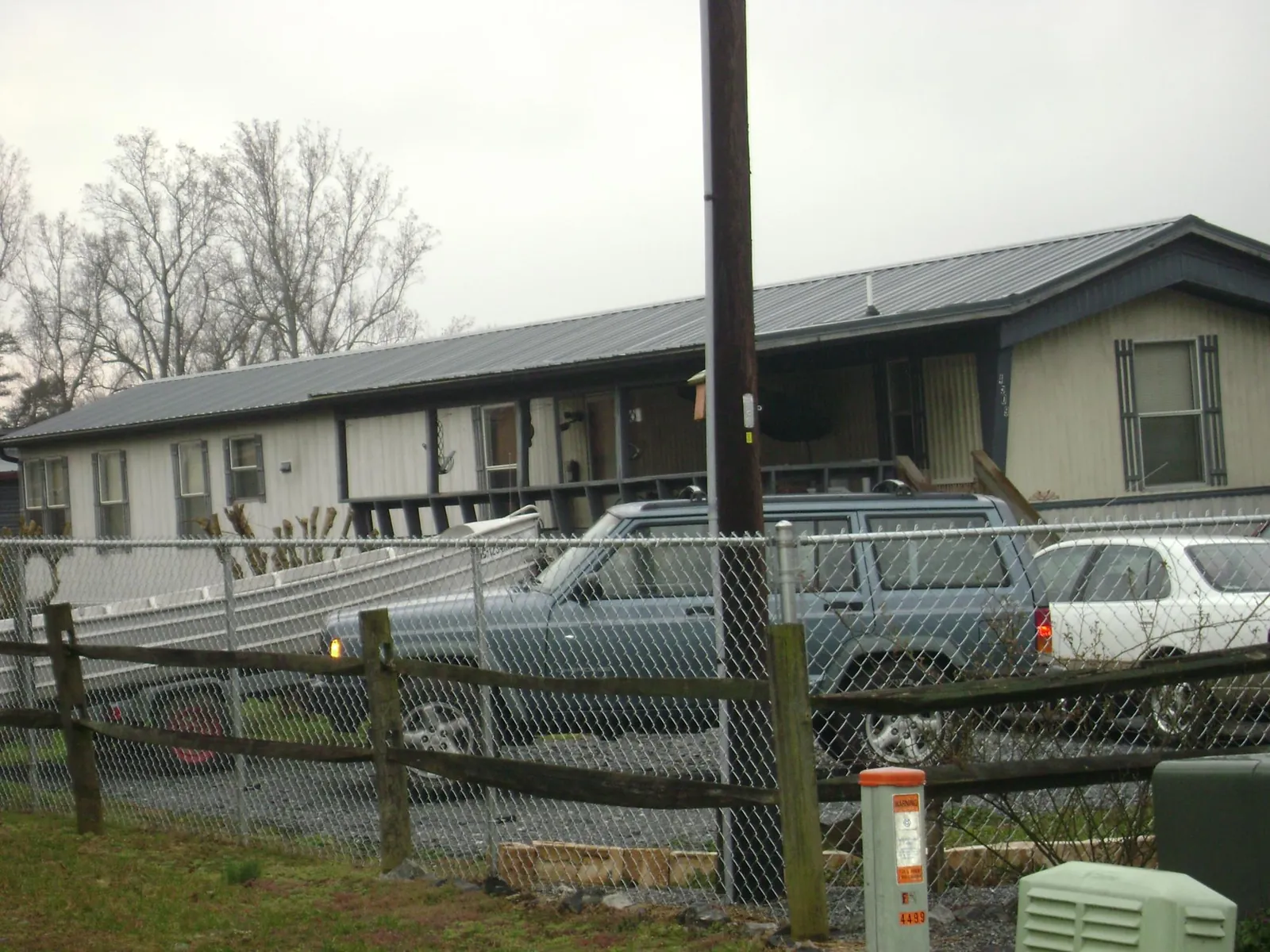 Dark metal roof on a long single story building behind a chain link fence in North Highlands