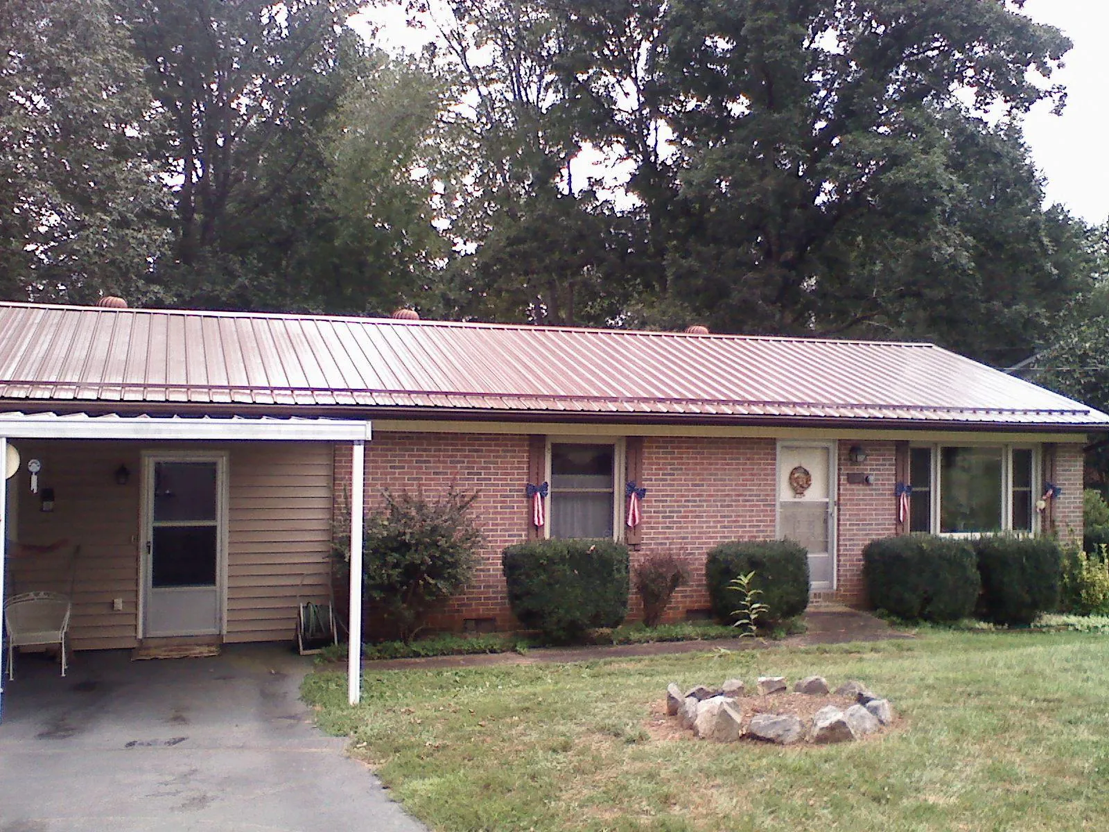 Bronze metal roof and carport on a brick ranch home — Roof Repair work by our crew in North Highlands